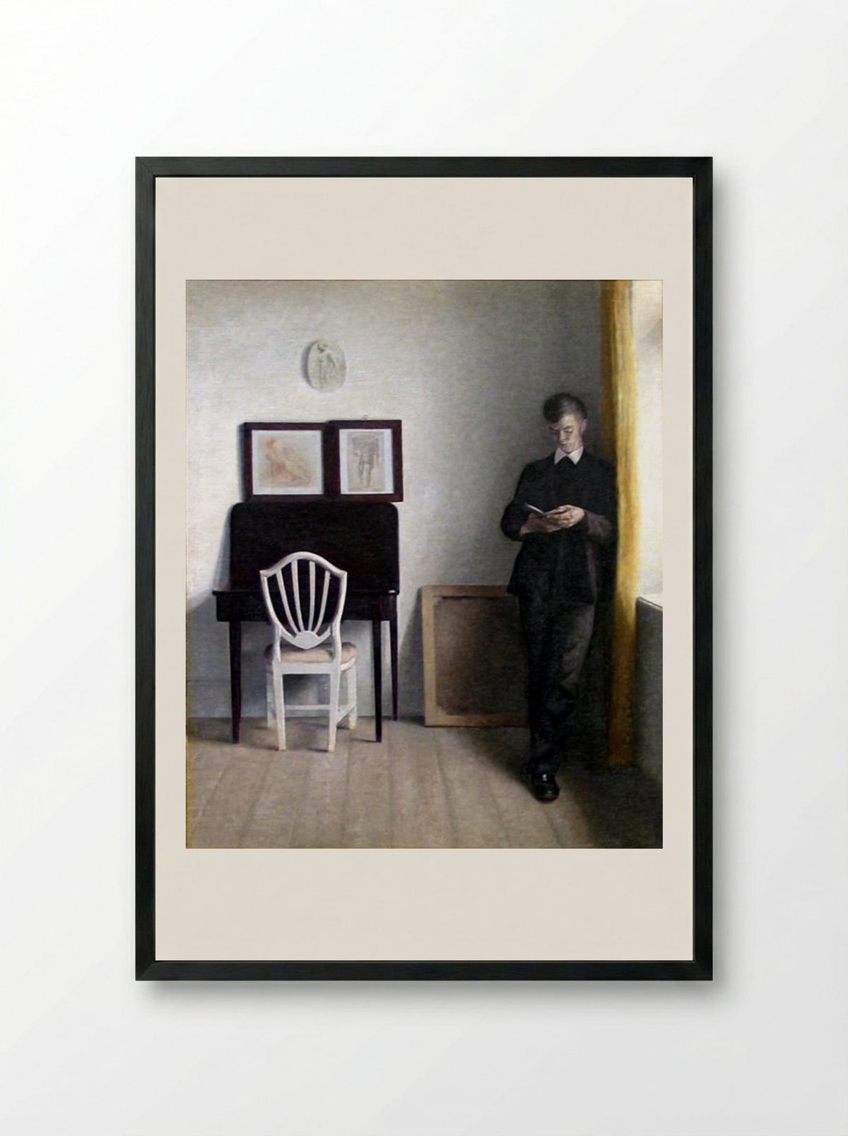 Interior with Young Man Reading - Vilhelm Hammershoi - Framed Print Black